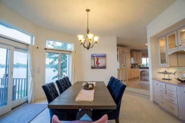 dining area with light colored carpet and an inviting chandelier