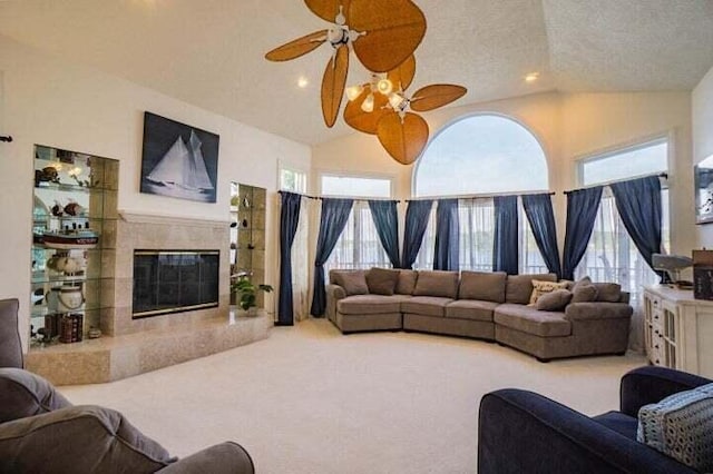 living room with lofted ceiling, ceiling fan, carpet floors, and a textured ceiling