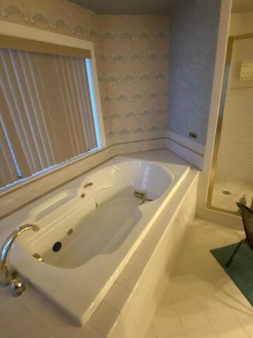 bathroom with tile patterned floors and independent shower and bath