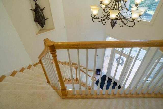 staircase featuring a chandelier