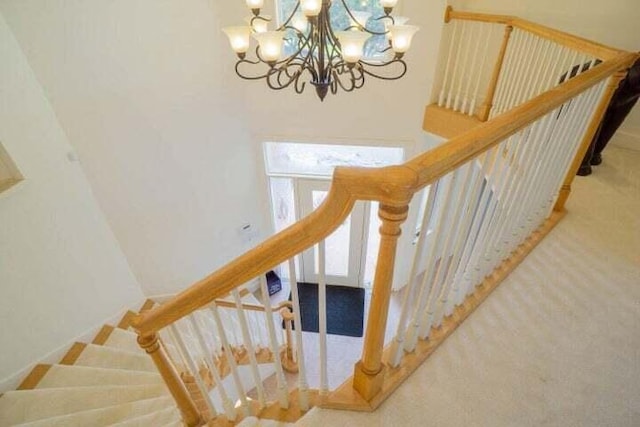 stairs featuring carpet floors and a chandelier