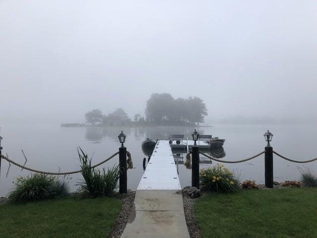 dock area with a water view and a lawn