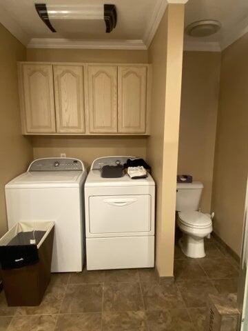 laundry room featuring ornamental molding and washing machine and dryer