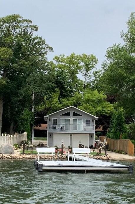 back of house featuring a water view and a balcony