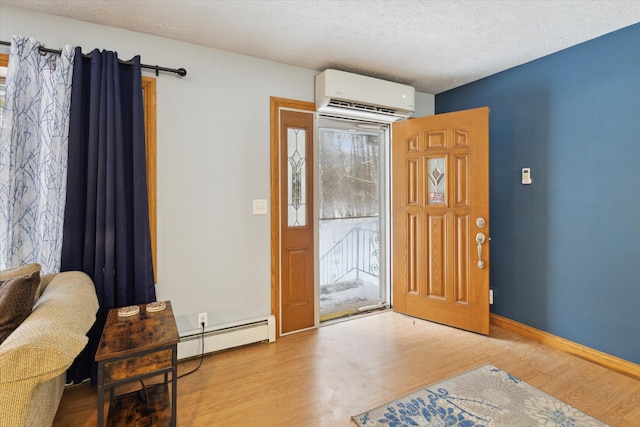 entryway featuring light wood-type flooring, a textured ceiling, a baseboard radiator, and a wall mounted air conditioner