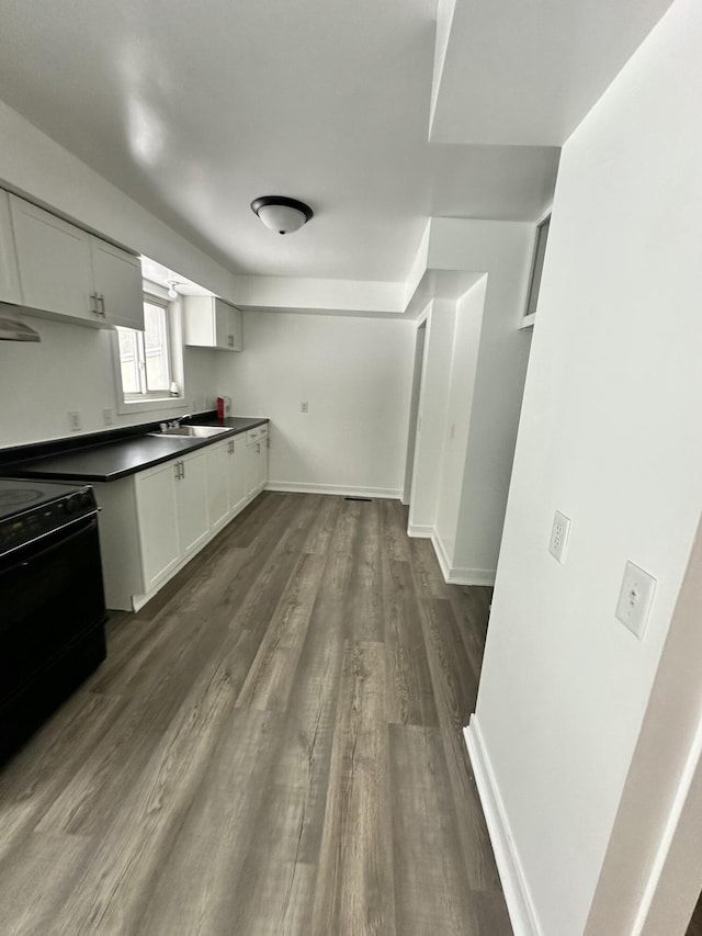 kitchen featuring electric range oven, dark hardwood / wood-style floors, sink, and white cabinetry