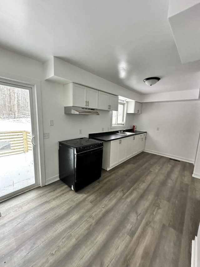 kitchen featuring black electric range oven, white cabinets, light hardwood / wood-style flooring, and sink