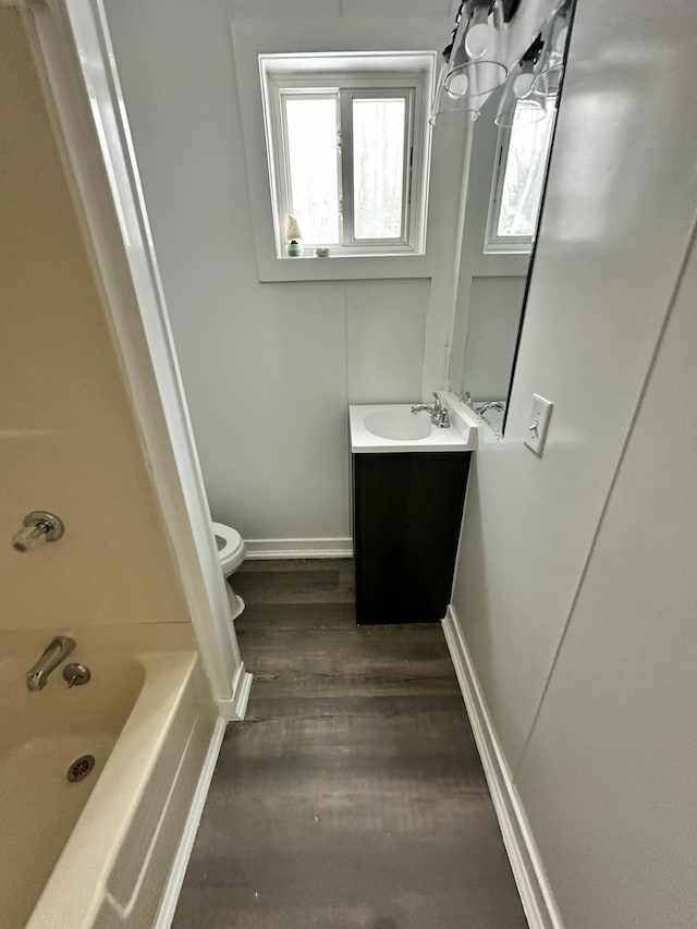 full bathroom with shower / bath combination, wood-type flooring, toilet, and vanity