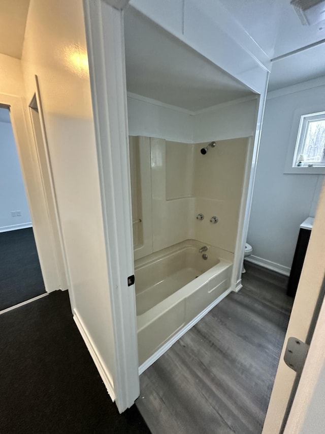 bathroom with toilet, wood-type flooring, shower / bathing tub combination, and ornamental molding