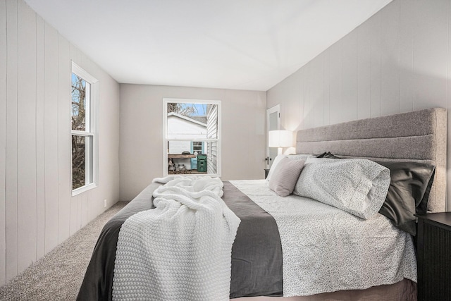 carpeted bedroom with wood walls