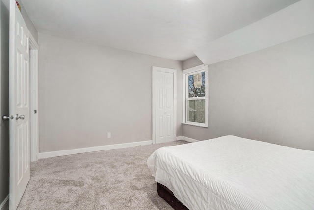 bedroom featuring light colored carpet and a closet