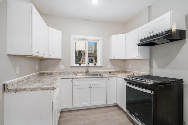 kitchen featuring white cabinetry, gas range, and sink