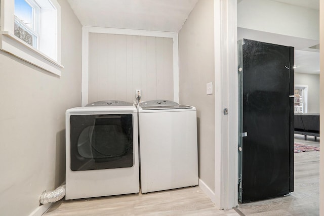 laundry area with light hardwood / wood-style floors and washer and dryer