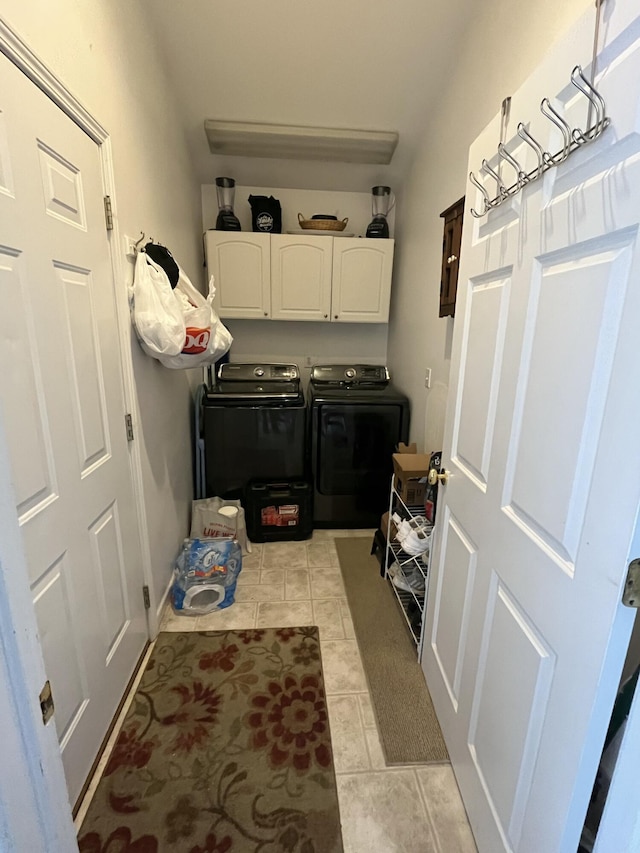 clothes washing area with light tile patterned floors, independent washer and dryer, and cabinets