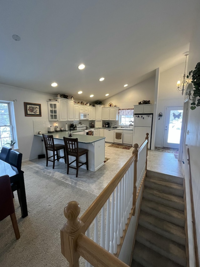 interior space with lofted ceiling, a wealth of natural light, and an inviting chandelier