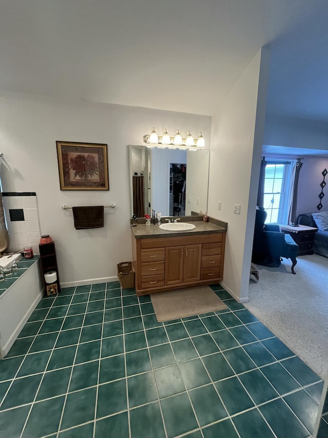 bathroom featuring a tub to relax in, vanity, and tile patterned floors