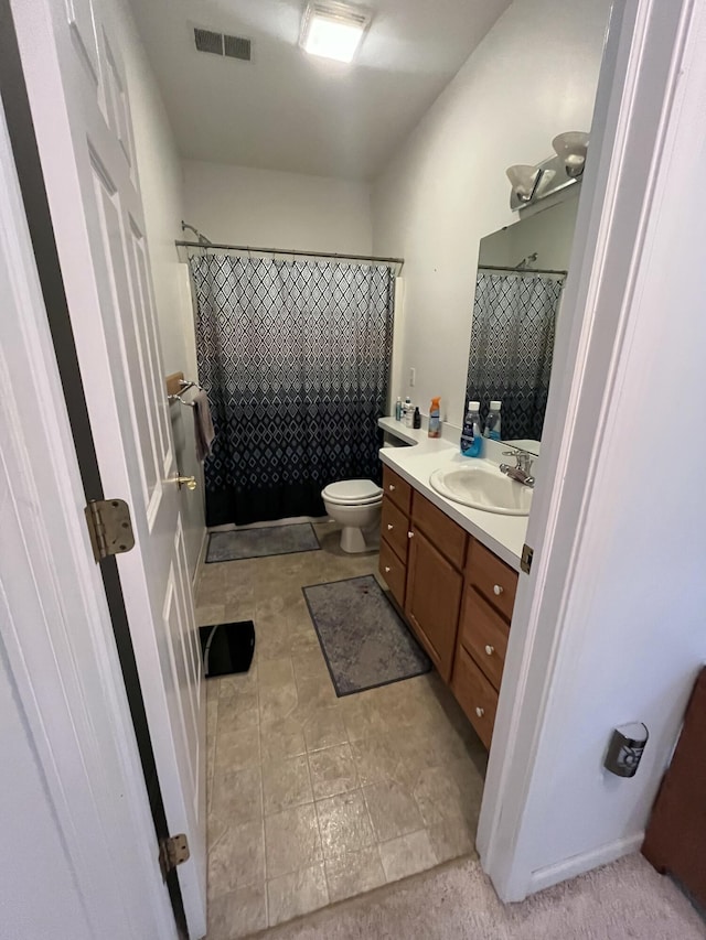 bathroom featuring toilet, a shower with shower curtain, and vanity