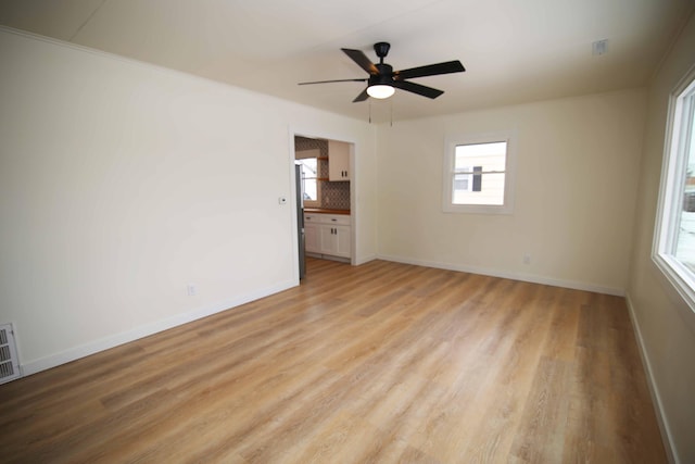 unfurnished room with ceiling fan and light wood-type flooring