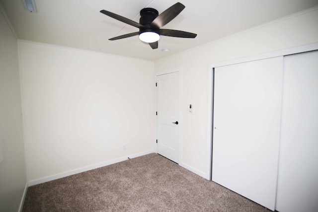 unfurnished bedroom featuring ceiling fan, carpet, and a closet