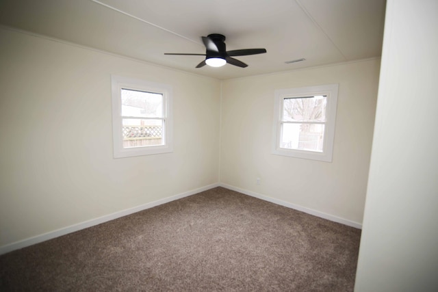 carpeted empty room with ceiling fan, ornamental molding, and plenty of natural light