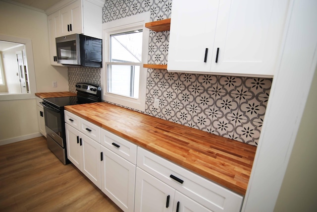 kitchen with white cabinets, butcher block countertops, backsplash, and stainless steel electric range