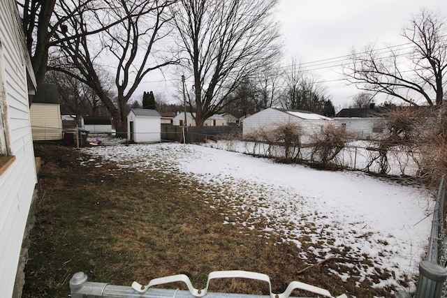 snowy yard with a storage shed