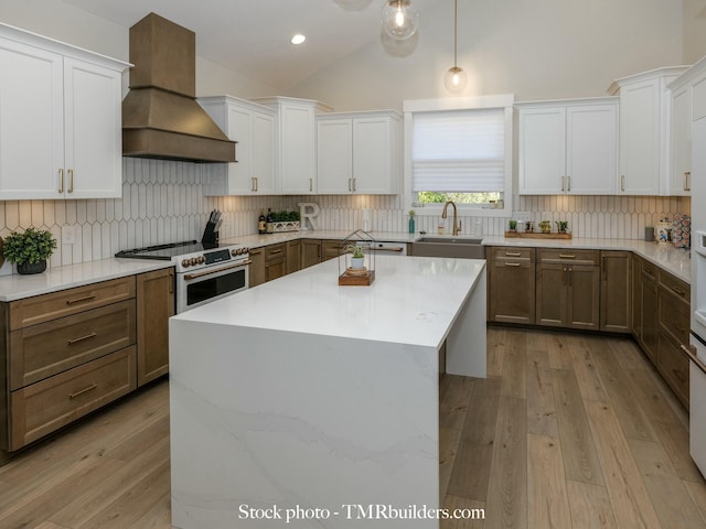 kitchen featuring custom exhaust hood, decorative backsplash, decorative light fixtures, white cabinets, and white range with electric cooktop