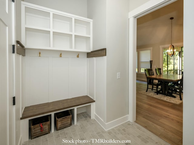 mudroom featuring hardwood / wood-style flooring and a notable chandelier