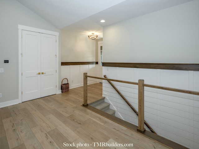 stairway with lofted ceiling and wood-type flooring