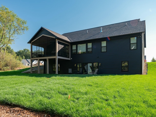 back of property featuring a sunroom and a lawn