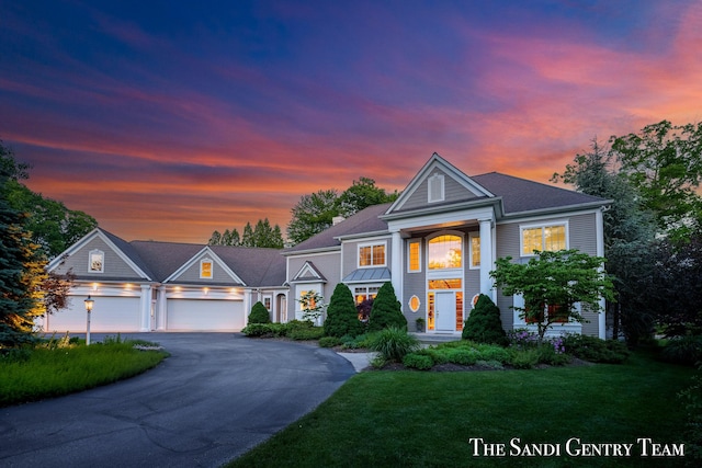 neoclassical / greek revival house with a garage and a lawn