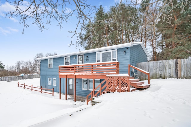 snow covered property with a deck