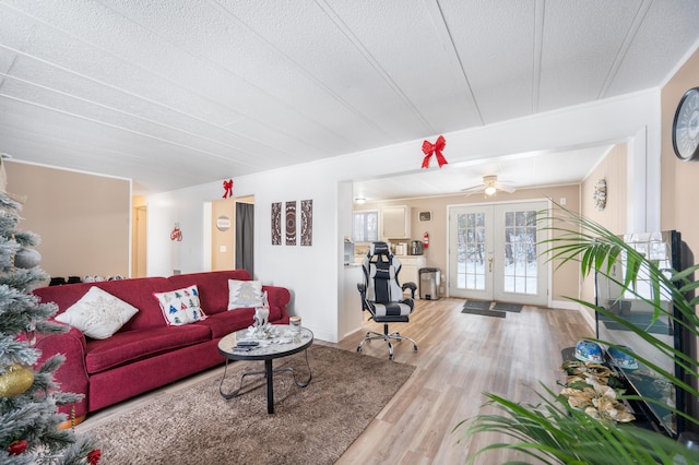 living room with french doors, crown molding, a textured ceiling, and hardwood / wood-style flooring