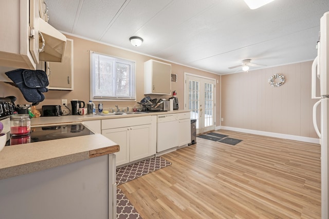 kitchen with sink, white appliances, light hardwood / wood-style flooring, ornamental molding, and french doors