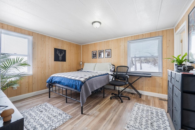 bedroom with wood walls and light wood-type flooring