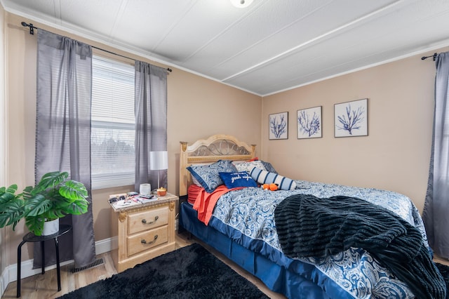 bedroom featuring crown molding and hardwood / wood-style flooring