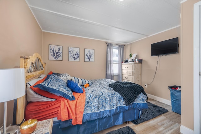 bedroom with crown molding and light hardwood / wood-style floors