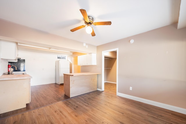 kitchen featuring sink, ceiling fan, hardwood / wood-style floors, white cabinets, and white fridge