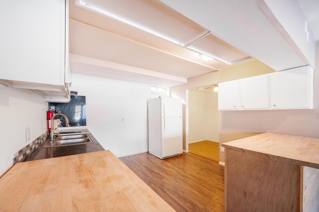 kitchen featuring sink, white cabinetry, white refrigerator, ceiling fan, and light hardwood / wood-style floors