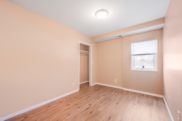 unfurnished bedroom featuring light hardwood / wood-style floors and a closet