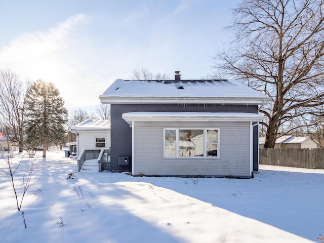 view of snow covered back of property