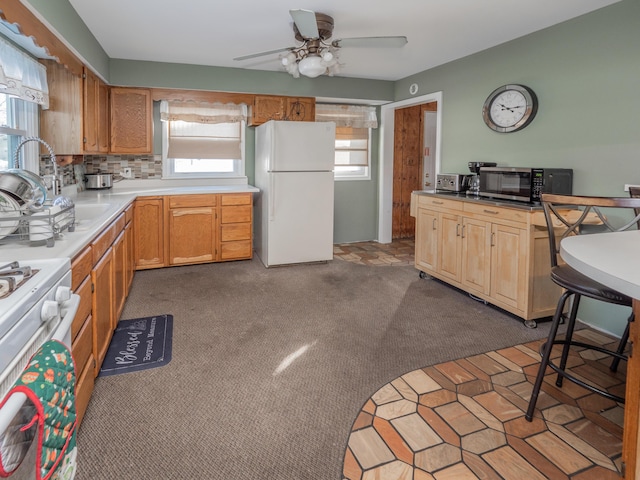 kitchen with ceiling fan, a wealth of natural light, white appliances, and carpet flooring