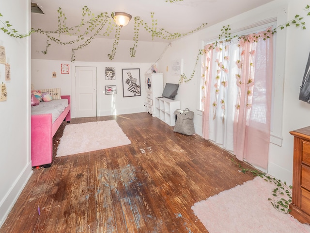 unfurnished bedroom featuring dark hardwood / wood-style flooring and lofted ceiling