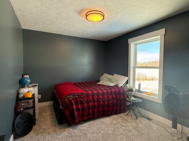 carpeted bedroom featuring a textured ceiling