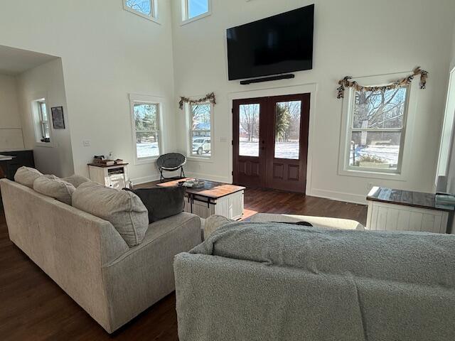 living room featuring french doors, a towering ceiling, and dark hardwood / wood-style floors