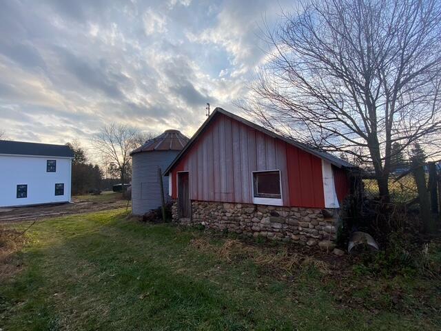 property exterior at dusk featuring a yard