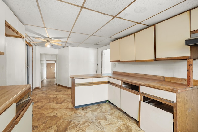 kitchen featuring ceiling fan, a paneled ceiling, and white cabinets