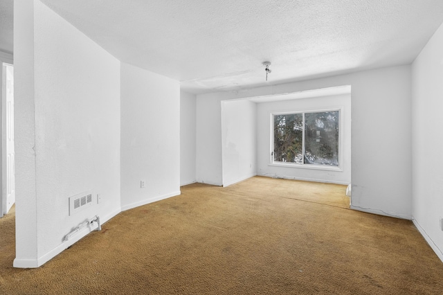 carpeted spare room with a textured ceiling