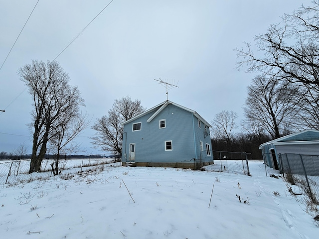 view of snow covered back of property