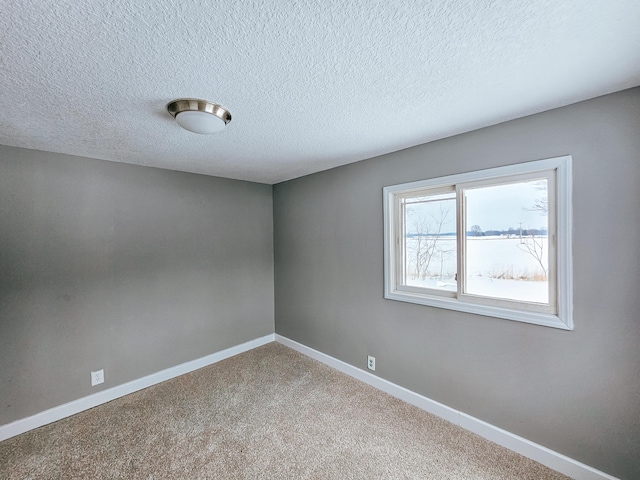 carpeted spare room with a textured ceiling and a water view